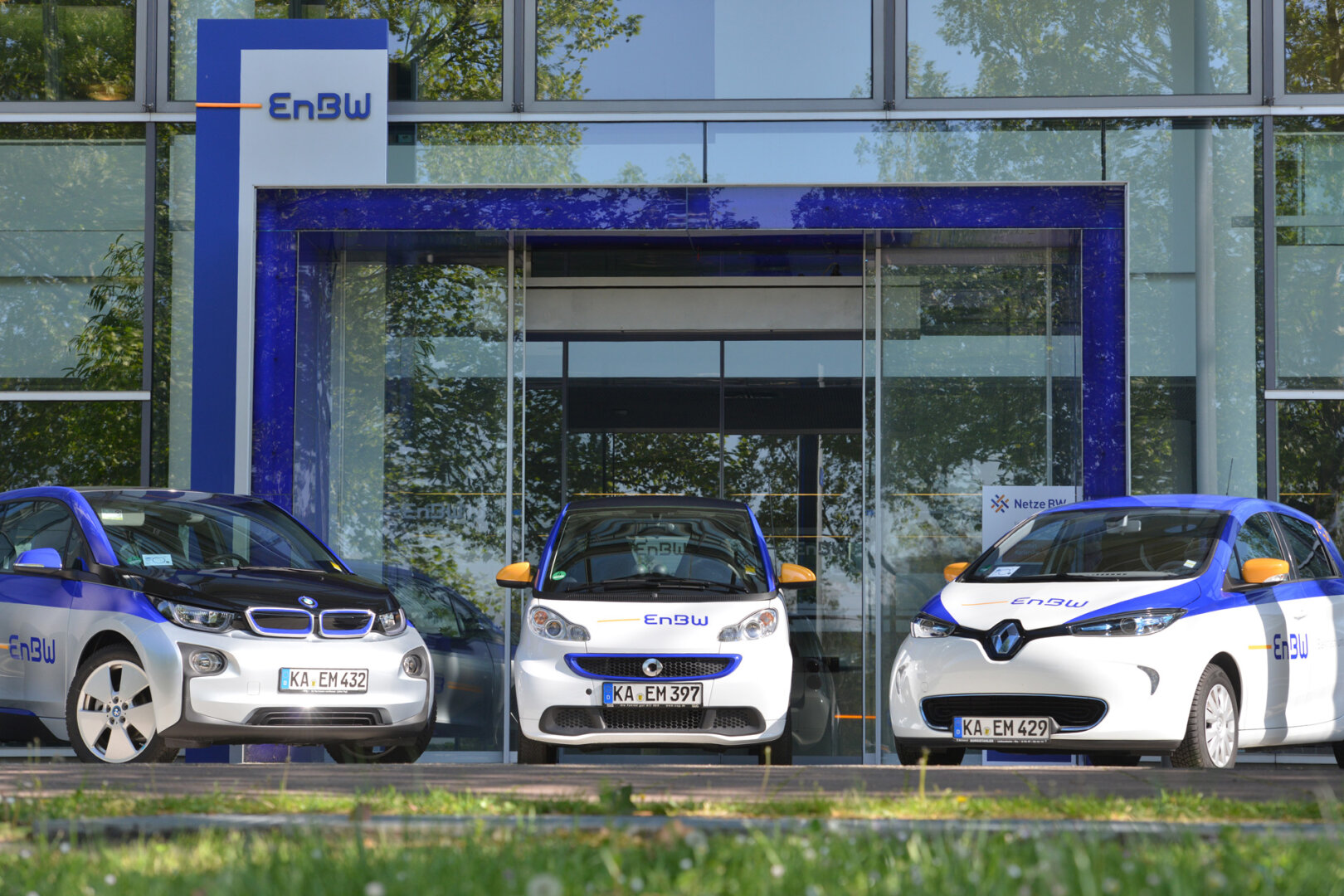 Drei weiße Renault E-Autos stehen in einer Reihe