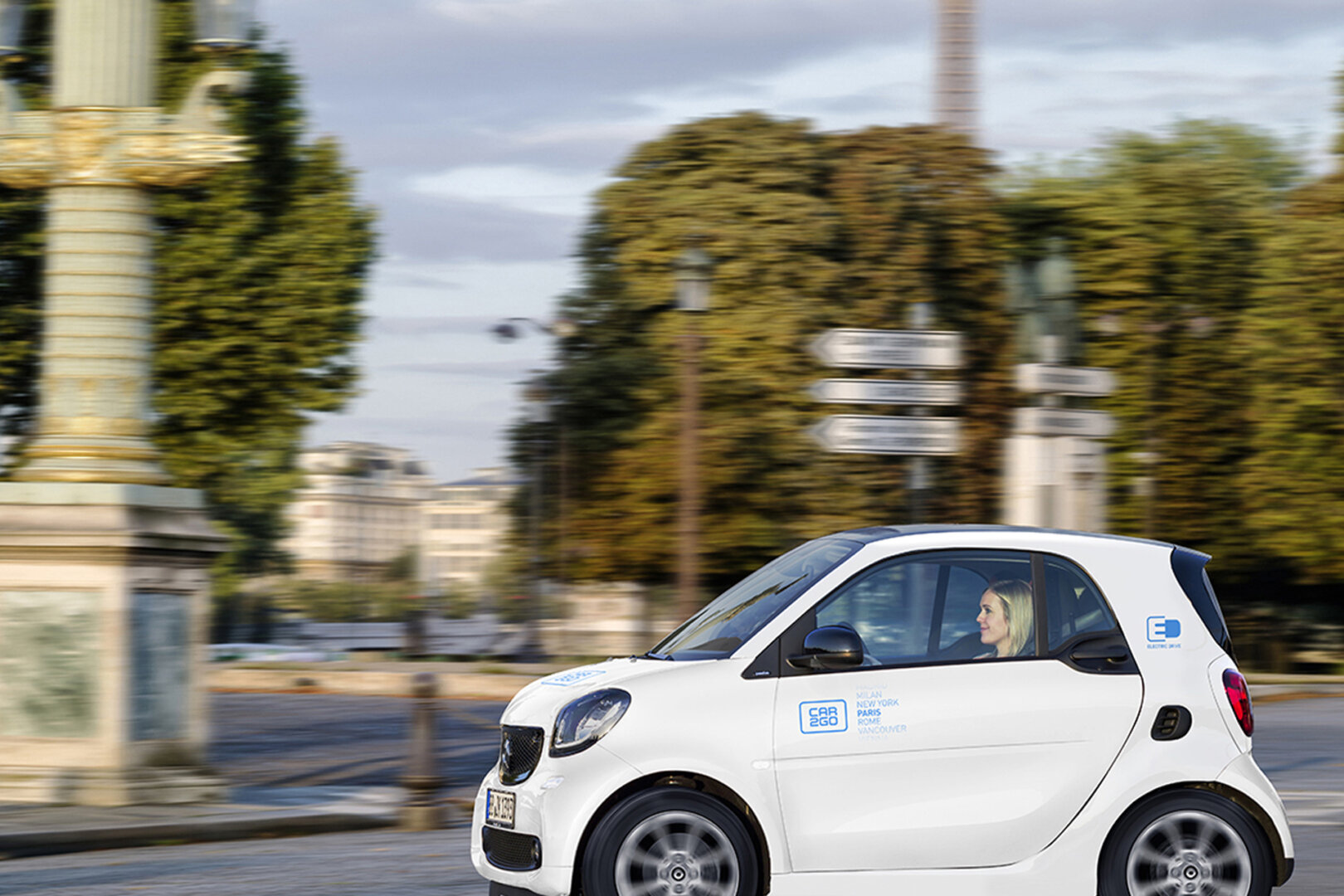 Elektroauto Weißer Smart von car2go fährt durch Paris