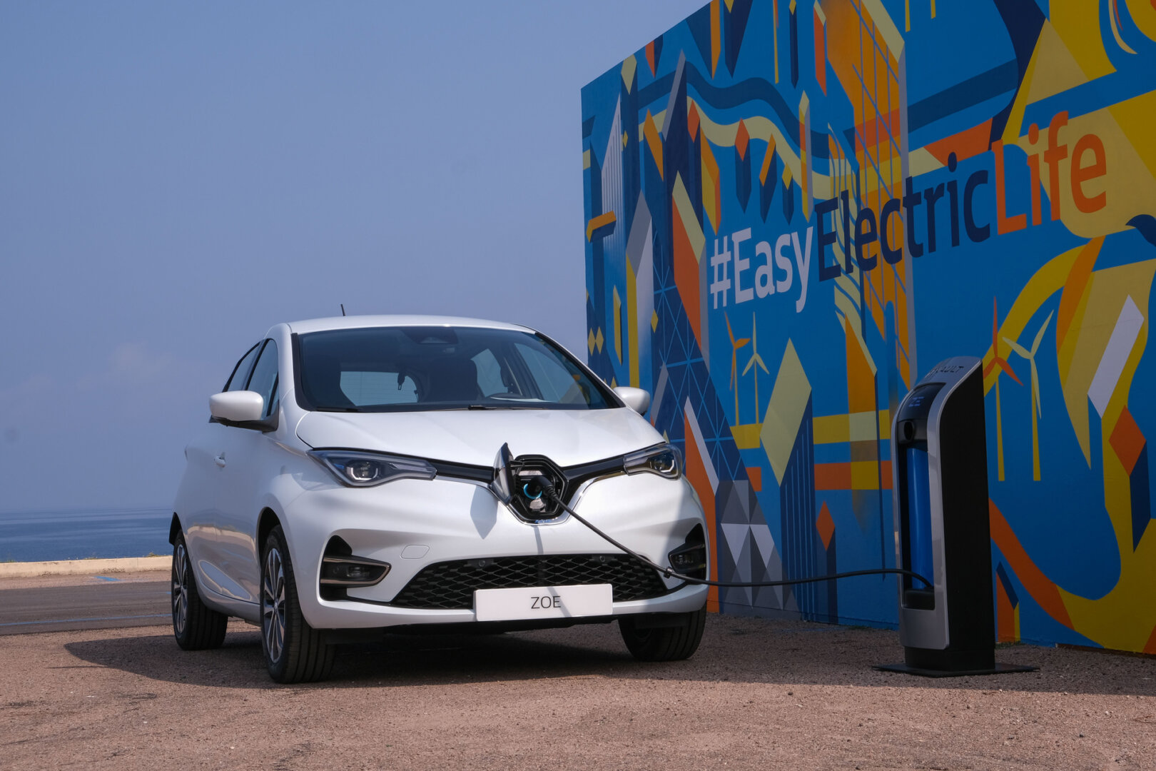 Weißer Renault Zoe wird an Ladestation geladen