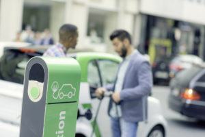 Zwei Männer laden Ihr Elektroauto an einer E-Ladestation