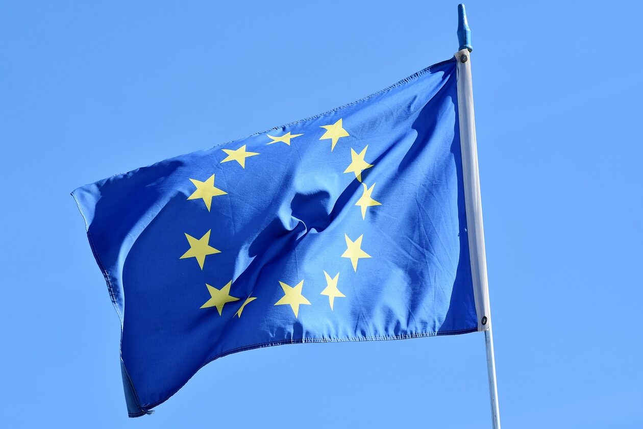 Eine Europa Flagge. Blauer Hintergrund und Flagge ist blau mit gelben Sternen.